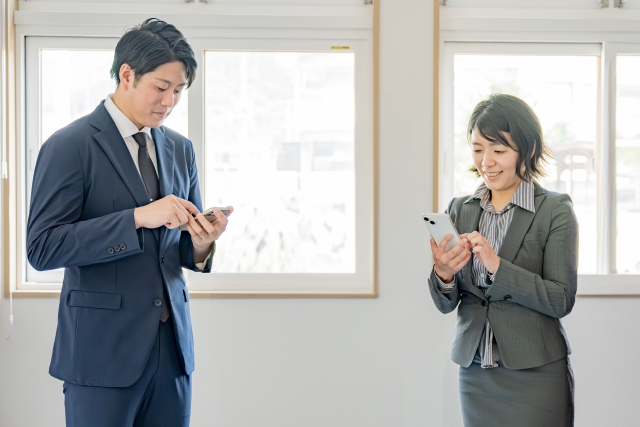 スマホを触るビジネス男女